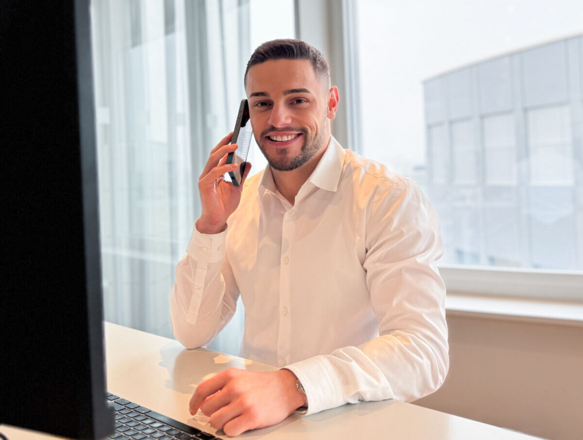 Lino lächelt in die Kamera und ist am telefonieren.