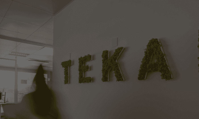 Person läuft an der Tekan Wand vorbei.