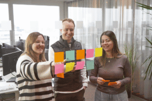 3 Personen legen ein Konzept mit Post-It